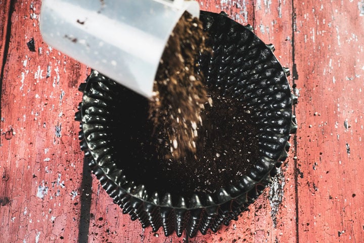 Pot Size and Type Rellenando una maceta de tela (air-pot o smart-pot) con sustrato de cultivo. Este tipo de maceta promueve una mejor aireación de las raíces y un crecimiento más saludable de la planta.